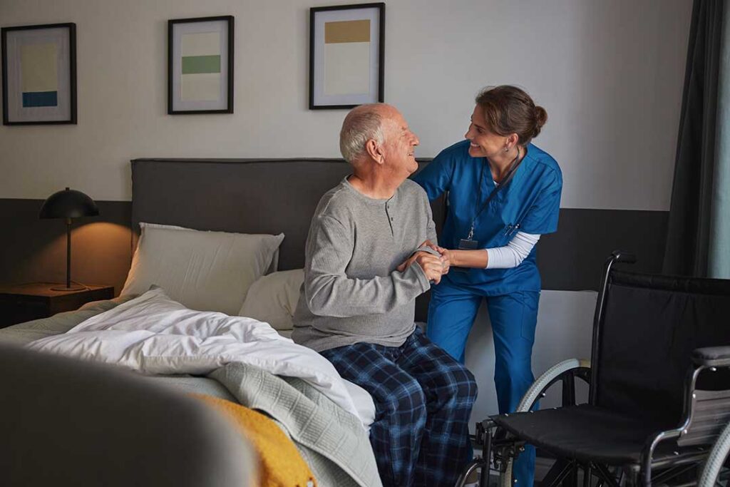 Older adults share a meal and conversation in a bright assisted living dining room.